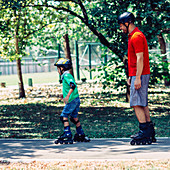 Father and son roller skating in park