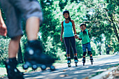 Family roller skating in park