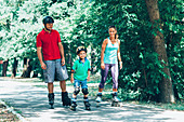 Family roller skating in park