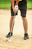 Golfer playing from sand trap