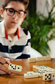 Boy playing dominoes