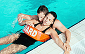 Lifeguard helping young woman