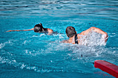 Lifeguard swimming towards drowning woman