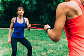 Women exercising with elastic bands in a park