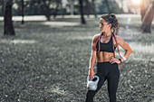 Woman in park with kettlebell and elastic band