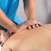 Physiotherapist massaging man's back
