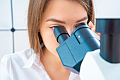 Researcher using microscope