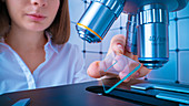 Researcher using microscope