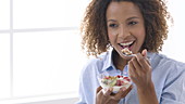 Woman eating fruit and yoghurt