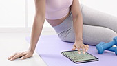 Woman exercising using digital tablet