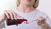 Woman pouring cough syrup