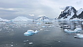 Ship in Antarctic sea with mountains