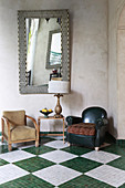 Seating on tiled chequered floor below mirror on wall
