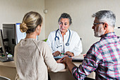 Doctor discussing with a couple during consultation