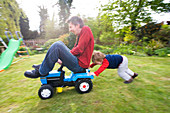 Boy pushing his father on tractor