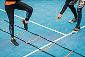 Young woman exercising with agility ladder