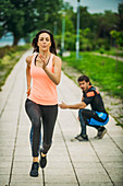 Female exercising by the river with personal trainer