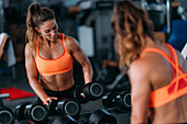 Woman exercising with weights in the gym