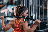 Woman using a lat machine in the gym