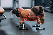 Female athlete doing push-ups in the gym