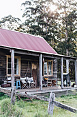 Rustikale Holzhütte mit Veranda, verwittertem Zaun und Wald