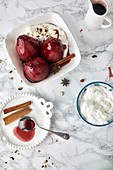 Pears poached in red wine sauce with spices served with mascarpone and cream