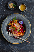 Salat mit Karottenstreifen und Radieschen mit Misosauce und Sesam