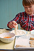 Boy preparing fish fingers