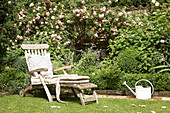 Lounger next to bed of climbing roses and box hedge