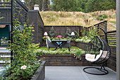 Hanging chair on terrace in split-level garden