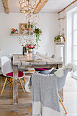 Autumnal decorations in dining area with wooden table and shell chairs