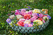 Bowl of rose petals, cranesbill and gooseberries