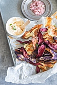 Colorful potato chips with harissa yoghurt