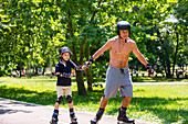 Grandfather teaching grandson to roller skate