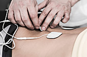 Placing TENS electrodes on lower back