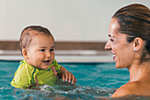 Baby boy and mother in swimming pool