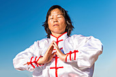 Women practicing tai chi by lake