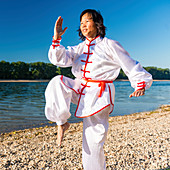 Women practicing tai chi by lake