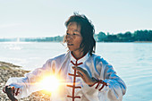 Women practicing tai chi by lake