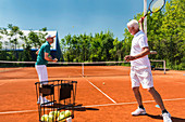 Senior man with tennis instructor