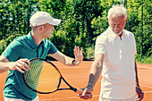 Senior man with tennis instructor