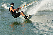 Wakeboarder cutting water surface