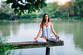 Woman meditating by a lake