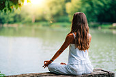 Woman meditating by a lake