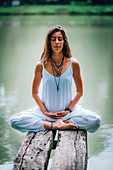 Woman meditating by a lake