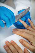 Filing fingernails at nail salon