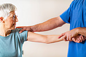 Physical therapist examining patient's elbow