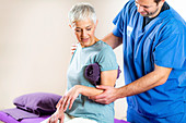 Physical therapist examining patient's arm