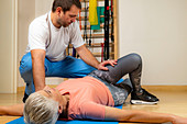 Physical therapist stretching senior woman