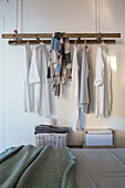 Old ladder suspended and used as clothes rack in bedroom